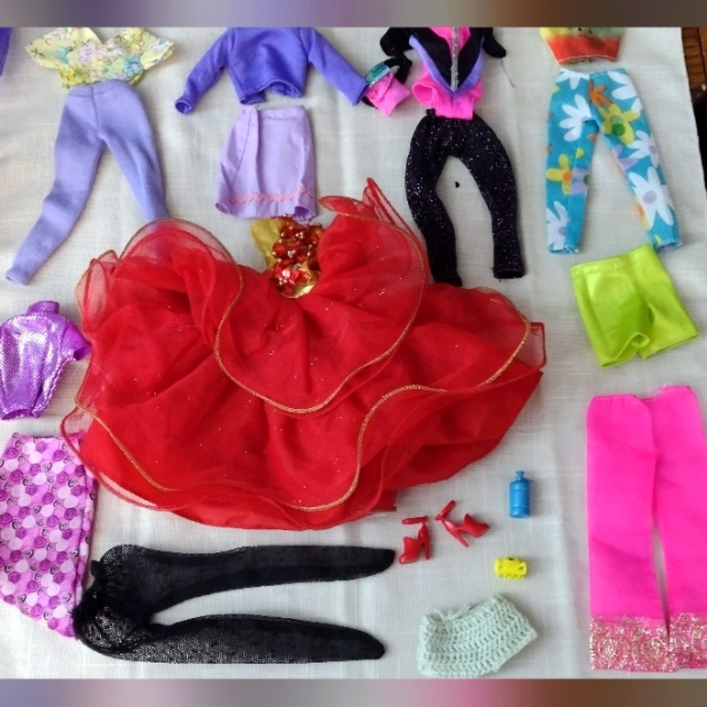 Lot of 15 pieces of barbie clothes and additional accessories.